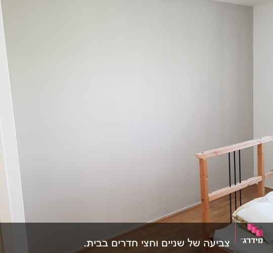 קיר צבוע בלבן עם רצפת עץ